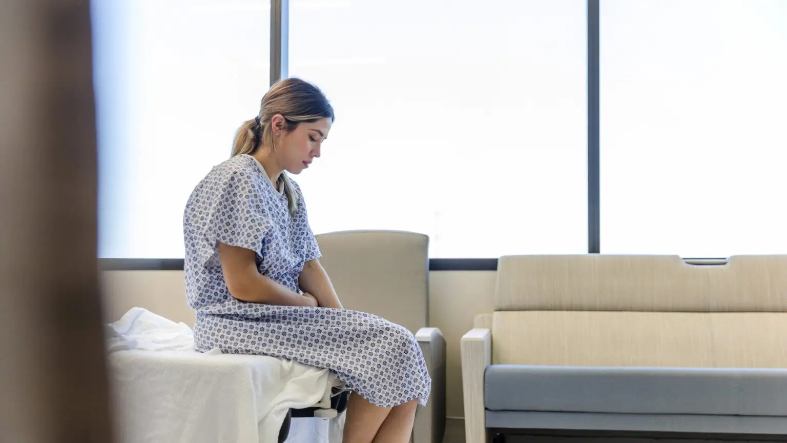 anxious young woman on hospital bed